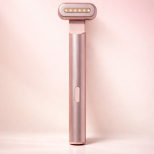 Front-facing view of a rose-gold 4 in 1 skincare wand standing upright on a soft pastel surface, with gentle studio lighting, subtle floral accents, and a calm, spa-inspired background.